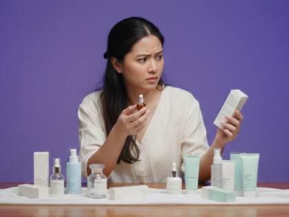 Woman checking skincare product packaging, highlighting the risks of fake skincare and counterfeit beauty products in the Philippines
